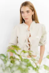 Blusa color blanco de lino, con mangas 3/4 y volados en el frente. Se ata con lazos en el centro.