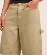 Bermuda masculina color beige, corte baggy relaxed, confeccionada en sarga lavada de algodón. Posee cintura con trabilla, cierre tradicional y bolsillo carpintero.