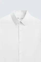 Camisa negra de manga larga, corte slim fit, con cuello italiano y cierre frontal de botonadura.