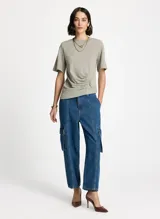 Remera color verde lavado, estilo camiseta, corte asimétrico, cuello redondo, manga corta y detalle fruncido lateral.