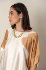 Blusa italiana color natural con estampado de hojas grandes en tonos marrones. Tiene cuello redondo y mangas cortas amplias.