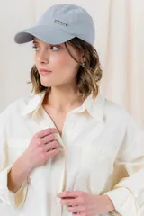Camisa color crema de algodón liviano, calce oversize, con cuello camisero, cierre abotonado, mangas largas con opción de arremangado y dos bolsillos frontales con solapa.