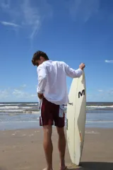 Short de baño color borgoña con cintura y laterales celestes.