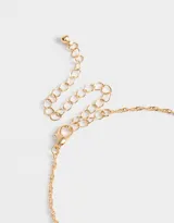 Collar corto dorado con dije de corazón de cuarzo rosa y estrella dorada.