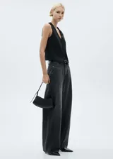 Chaleco negro con cuello en pico, diseño crop y cierre frontal con botones.