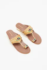 Sandalia de cuero color marrón con bordados de hilo y lentejuelas doradas. Tiene taco cuadrado color hueso de 3 cm de altura.