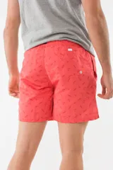 Short de baño azul con estampado de hojas de palmera en tonos azules, blancos y rosados.