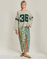 Sweater tejido color gris con el número 36 en verde en el frente y dos rayas verdes en las mangas.