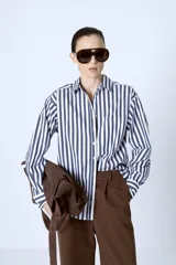 Camisa celeste con rayas verticales blancas, de corte clásico y manga larga.