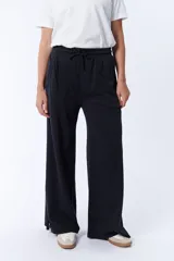 Pantalón deportivo ancho negro con cintura elastizada y cordón ajustable.
