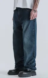Pantalón de denim azul oscuro, corte wide leg y cinco bolsillos.