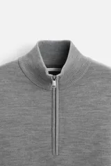 Jersey azul marino de punto suave, corte regular, cuello alto con cremallera frontal, manga larga y terminaciones en rib.