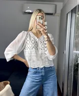 Camisa color crema con detalles de encaje y mangas largas abullonadas de gasa.
