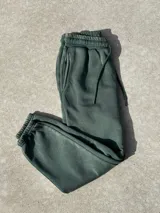 Jogger de felpa color verde, con ajuste en la cintura y en los tobillos, caracterizado por ser cómodo y casual.