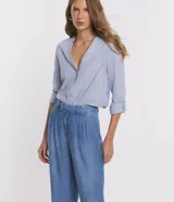 Pantalón pantalona de jean celeste, de corte ancho, con cintura media desplazada, pliegues delanteros y bolsillos.