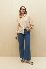 Camisa color beige con bordados florales, cuello clásico, cierre con botones y mangas 3/4 abullonadas.