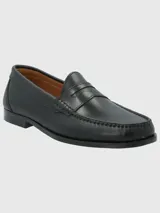 Zapato mocasín de cuero negro, con antifaz y suela de cuero y goma.