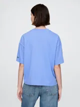 Remera corta color blanco con logo de Gap estampado en el frente y mangas cortas con detalle de rayas horizontales.
