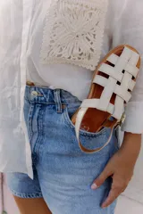 Sandalias de cuero marrón con tiras entrecruzadas y hebilla dorada al tobillo.