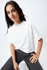 Remera negra de corte holgado con mangas ranglan y cuello redondo con bordado de estrellas blancas.