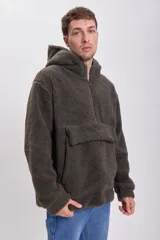 Buzo de hombre tipo canguro, confeccionado en tejido sherpa color visón. Tiene capucha, cierre parcial con cremallera y bolsillo tipo parche en el pecho.