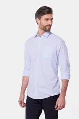 Camisa de lino color beige, de manga larga, con cuello clásico y bolsillo en el pecho.
