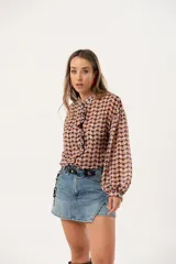 Minifalda de jean azul claro con corte evasé, detalle de short interno y cinturón negro con argollas metálicas.