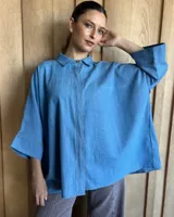 Camisa celeste de mangas largas con cuello clásico y cierre frontal con botones.
