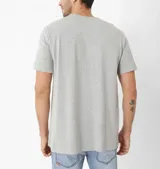 Remera gris de algodón con estampa frontal de un tractor Caterpillar D9 y texto en color negro y naranja.