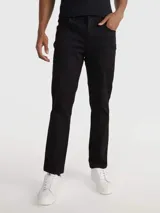 Pantalón de corte slim color negro, confeccionado en algodón y elastano, con diseño de cinco bolsillos, cierre con botón y cremallera, detalles distintivos de Calvin Klein y logo en el bolsillo trasero.