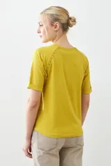 Remera color verde pistacho, de corte recto y manga corta raglán con detalle de vainillas en los hombros.