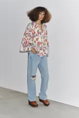 Camisa de algodón color crudo con estampado de cachemir en tonos rojo, azul y verde. Tiene cuello redondo, escote en pico, manga tres cuartos acampanada y bajo asimétrico redondeado.