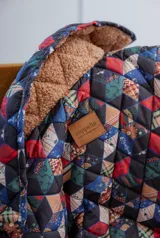 Campera capitoneada a mano con diseño geométrico multicolor, forrada en corderito con relleno de guata y tela impermeable.