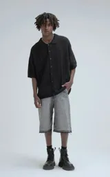Camisa negra de manga corta tejida de punto abierto con calce oversize.
