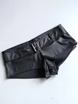 Short negro de cuero sintético con cinturón con hebilla metálica.