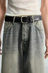 Pantalón de jean gris oscuro, de corte holgado y amplio en toda la pierna. Tiro medio y tejido rígido.