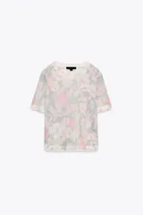 Top de punto con estampado floral en tonos rosa, gris y blanco. Tiene cuello redondo, mangas cortas y terminaciones acanaladas.