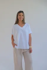 Remera blanca de corte holgado con cuello en V y mangas cortas con dobladillo.