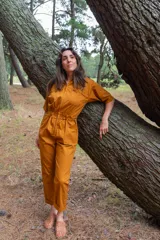 Mono color ocre de gabardina 100% algodón, con corte clásico, cierre frontal completo, pantalón largo con bolsillos, manga corta y cintura fruncida en la espalda.