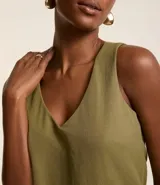 Musculosa verde oliva de piquet con escote en pico, breteles anchos, pequeñas aberturas laterales y bajos con pespuntes.
