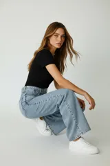 Pantalón jean ancho de calce medio, color celeste claro, con cintura alta y bolsillos traseros.