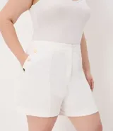 Bermuda de crepé color rojo, con pliegues frontales y botones decorativos en los bolsillos laterales.