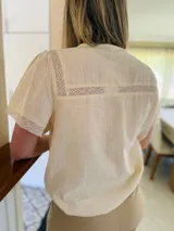 Camisa color amarillo manteca de lino, con cuello a la base, tablitas en el frente y puntilla.