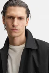 Sobrecamisa negra de algodón con cuello solapa, manga larga con puños abotonados, bolsillos de parche en el pecho y cierre frontal con botones. Corte relaxed fit.