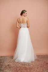 Vestido largo de microtul blanco con brillo y apliques de flores, con breteles finos y falda con vuelo. Ideal para quinceañeras.