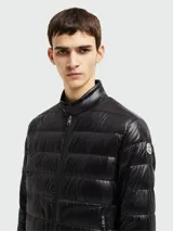 Campera puffer Moncler modelo Acorus, color verde oscuro, de corte entallado y largo a la cadera. Confeccionada en tejido técnico acolchado, cierre frontal con cremallera, cuello mao y bolsillos laterales con cremallera. Plegable y fácil de transportar.