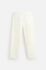 Pantalón chino color crema de corte recto, confeccionado en tejido de algodón con elasticidad. Cuenta con bolsillos frontales y traseros de plastrón con botón. Cierre frontal con cremallera y botón.