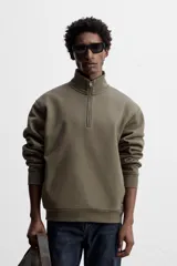 Sudadera negra de algodón con cuello alto y cierre de cremallera frontal. Corte relaxed fit, manga larga y terminaciones en rib.