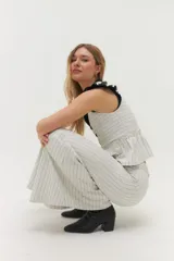 Pantalón de vestir blanco con finas rayas verticales negras, de corte palazzo y cintura alta.