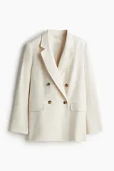 Blazer color crema de lino con doble botonadura, solapas de muesca y bolsillos delanteros ribeteados con solapa. Forrado.